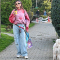 Bunico Smiley Handsfree Tasma bele takılı, elinde kahve olan kadın beyaz köpekle parkta yürüyor